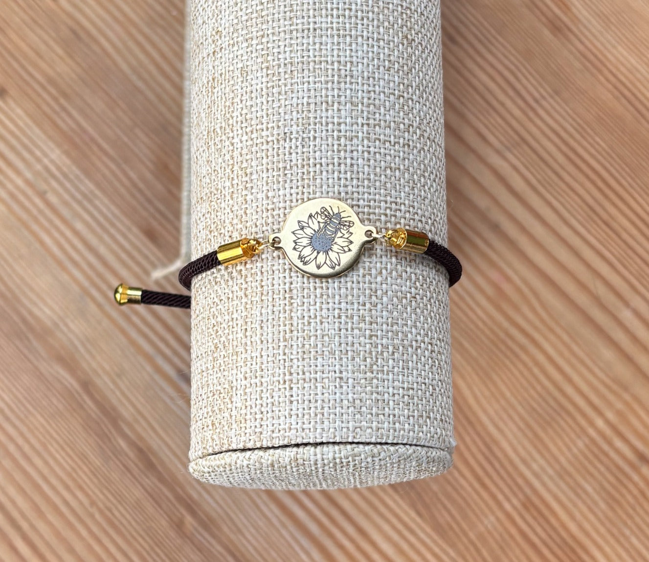 Bumble bee on sunflower on 21mm round golden on textile cord brown