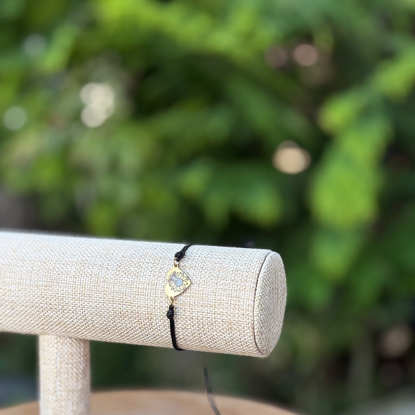 Bumble bee on sunflower on heart 14x12mm golden on thin cord black