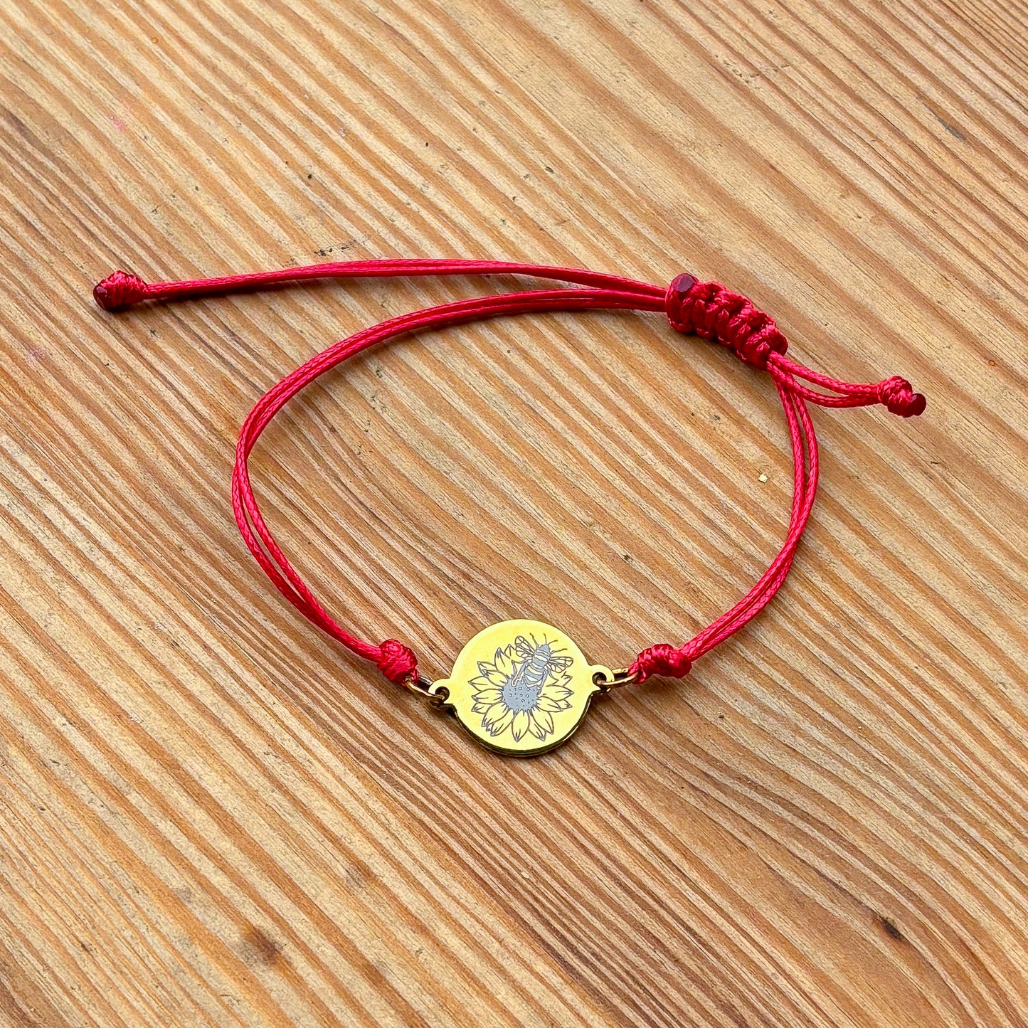 Bumble bee on sunflower on 21mm round golden on thin cord red