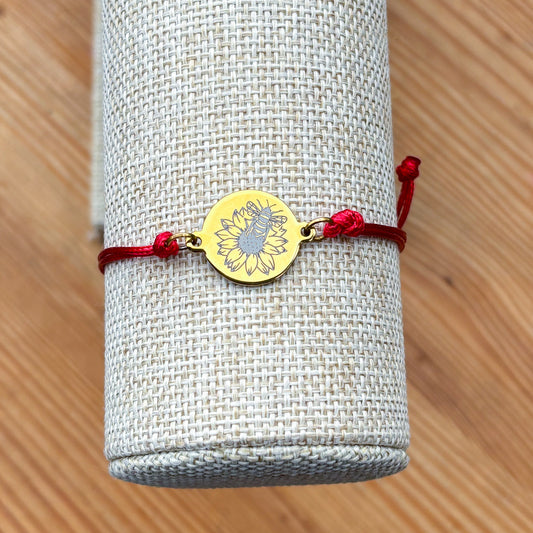 Bumble bee on sunflower on 21mm round golden on thin cord red