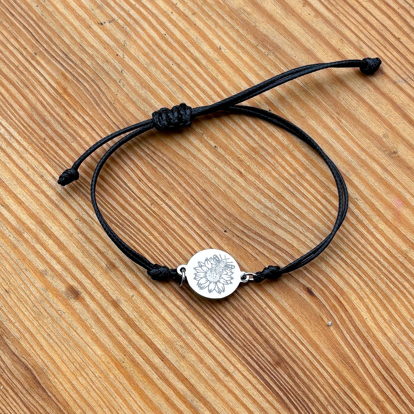 Bumble bee on sunflower on 21mm round silver on thin cord black