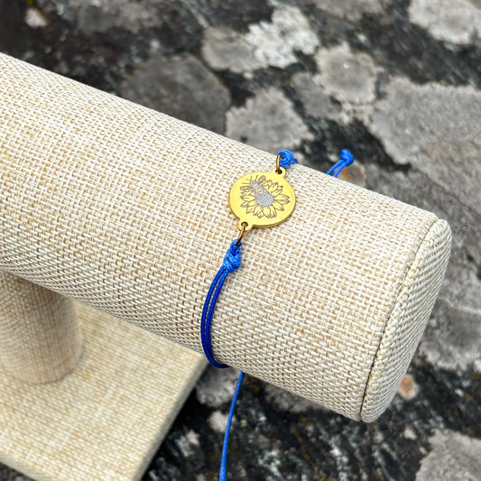 Bumble bee on sunflower on 21mm round golden on thin cord blue